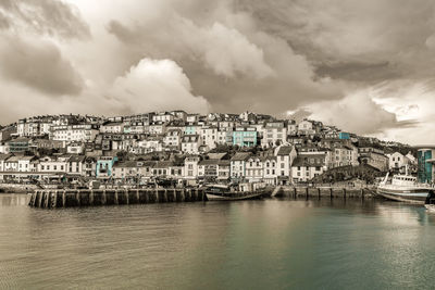 Aerial view of townscape by sea against sky