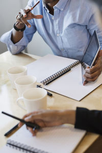 Cropped image of business people discussing at table