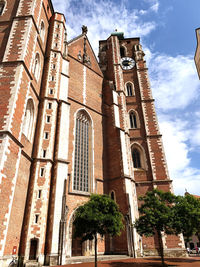 Low angle view of trees and building against sky
