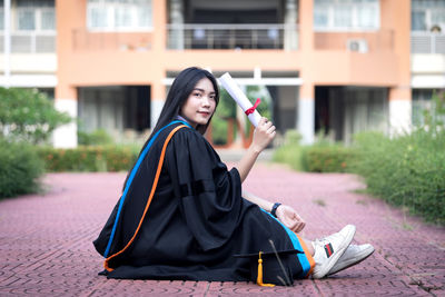 Portrait of beautiful woman sitting in city