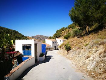 Houses and buildings against clear blue sky