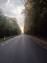 Empty road with trees in background