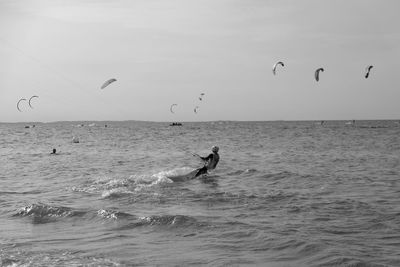 People enjoying in sea against sky