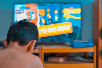 Rear view of shirtless boy at home