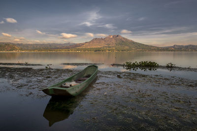 Scenic view of lake by mountains against sky