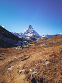 Scenic view of mountains against blue sky