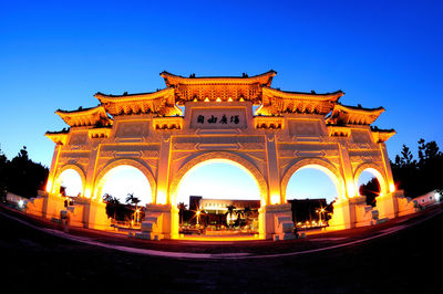 Low angle view of illuminated building against blue sky