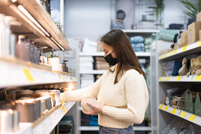 Young woman wearing face mask and protective gloves in store. today people lifestyle concept