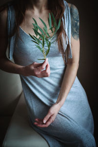 Midsection of woman holding plant