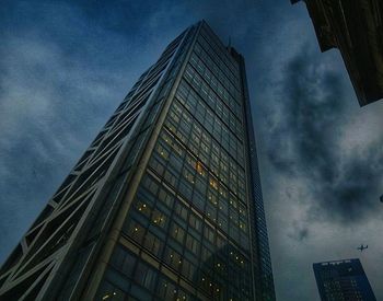 Low angle view of buildings against cloudy sky