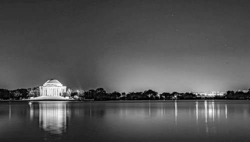 Reflection of buildings in lake at night