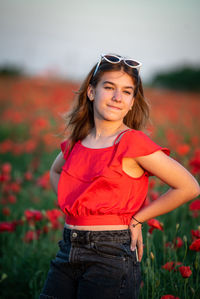 Portrait of young woman standing against plants