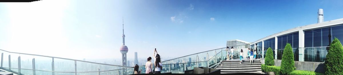 People in front of building against clear sky