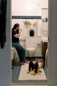 Mother and daughter brushing teeth in bathroom