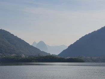 Scenic view of lake by mountains against sky