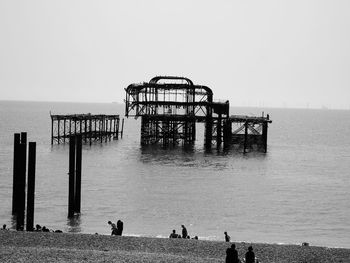 People on beach against clear sky