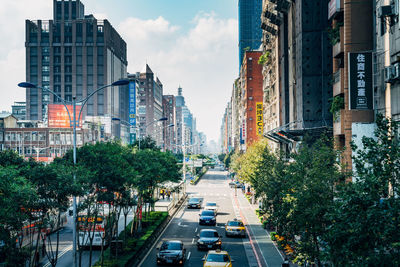 Cars on road amidst buildings in city