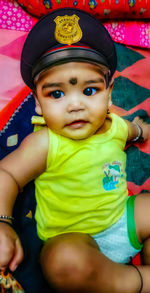 Portrait of cute baby girl sitting outdoors