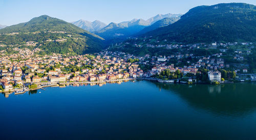 Town by lake and mountains against sky