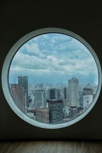 Cityscape against sky seen through glass window