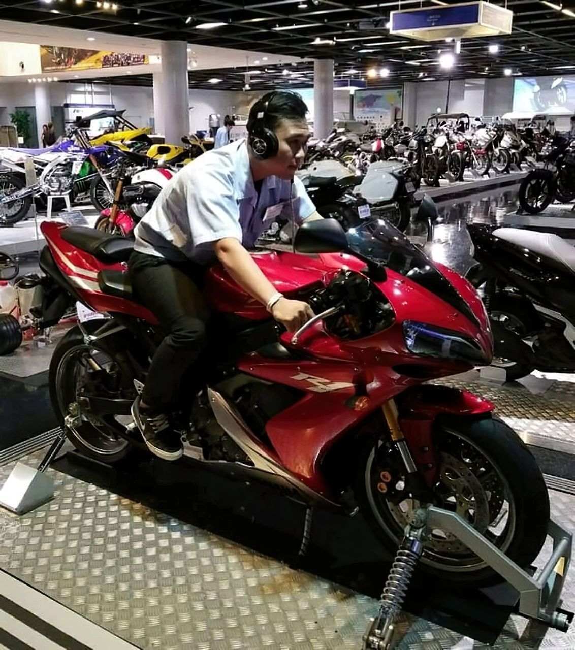 WOMAN SITTING ON MOTOR SCOOTER AT SHOP