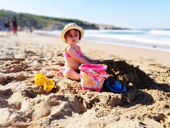 Portrait of cute baby girl playing on beach