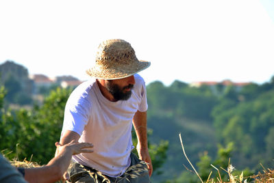 Man wearing hat on field against sky
