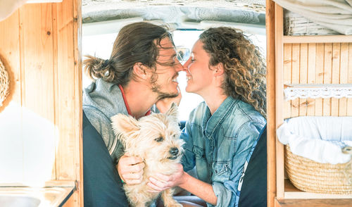 Happy couple with dog romancing in caravan