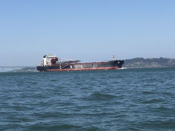 Ship sailing on sea against clear sky