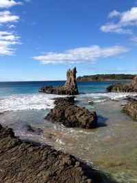 Rock formation on beach against sky