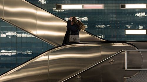 Woman standing on escalator