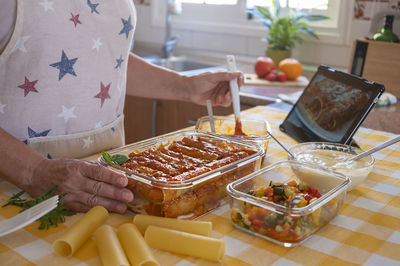 Midsection of senior woman preparing food in kitchen