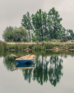 Boat moored in lake against trees