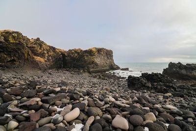 Rocks on beach against sky