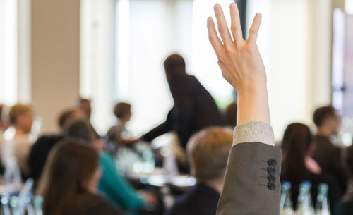 Close-up of businessman with hands raised at meeting