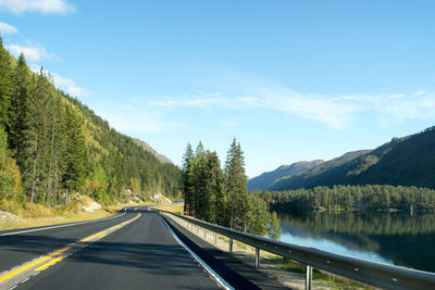 Road amidst trees against sky