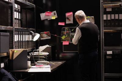 Rear view of man working at table