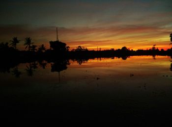 Scenic view of lake against sky at sunset