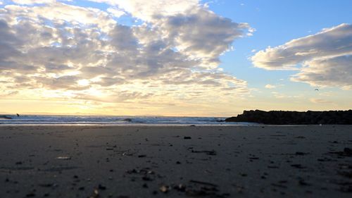 Scenic view of beach against sky during sunset