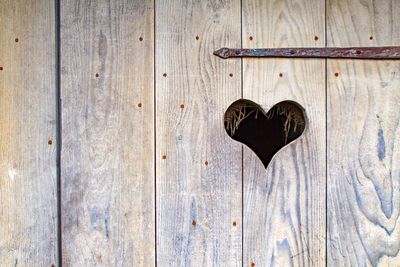 Heart shape amidst wooden wall
