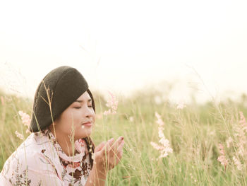 Close-up of woman with eyes closed sitting amidst plants