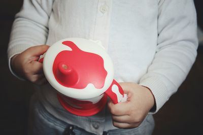 Midsection of girl holding baby cup