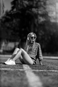 Young woman sitting on footpath