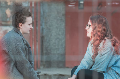 Side view of young couple sitting outdoors