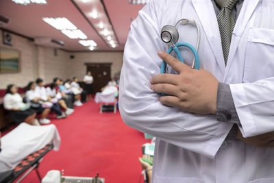 Midsection of doctor holding stethoscope