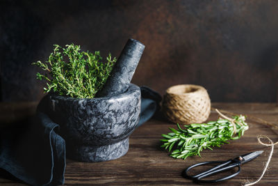Close-up of mortar and pestle with herbs on table
