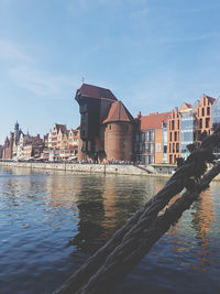 River by buildings against blue sky