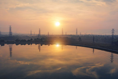 Scenic view of factory against sky during sunset