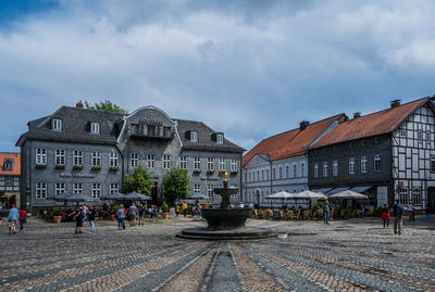 People walking on street against sky