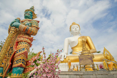 Low angle view of statue against temple against sky